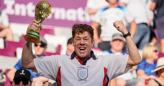 Andy Milne, aficionado inglés, posa con una Copa del Mundo en el estadio de Catar 2022.