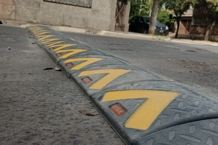 Trabajadores instalando un reductor de velocidad en una calle cercana a una escuela
