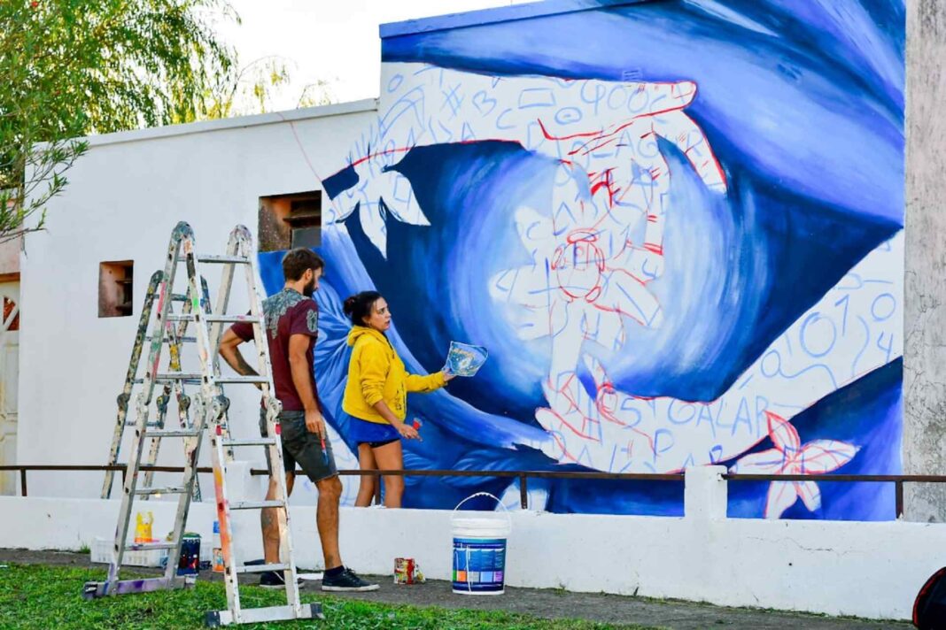 Artista trabajando en un mural en una pared de Entre Ríos