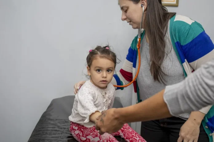 entre-rios-refuerza-atencion-enfermedades-respiratorias-ninos-postas-capacitacion Profesional de la salud y un niño en un centro de atención médica en Entre Ríos