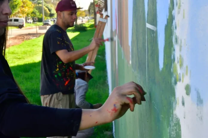 Personas participando en la creación de un mural comunitario en la provincia de Entre Ríos.