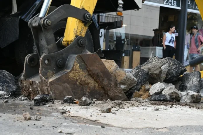 Personal de Obras Sanitarias trabajando en calle Montevideo con maquinaria y conos de seguridad
