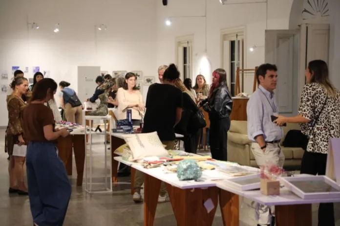 Visitantes recorriendo la muestra y feria de arte en el espacio AURA de Entre Ríos.