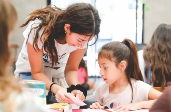 Niños participando en una clase de apoyo escolar en un espacio comunitario.