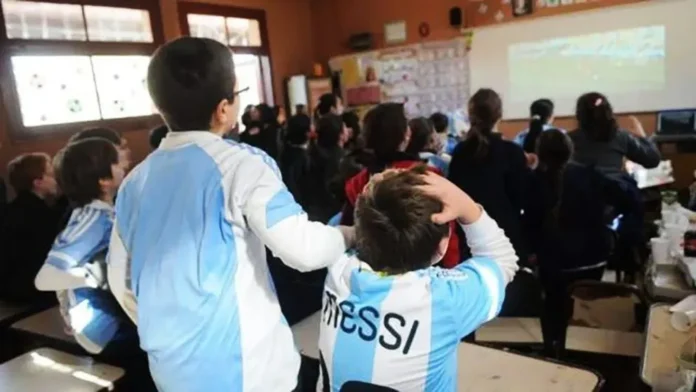 Estudiantes en aula con elementos de fútbol y computadoras